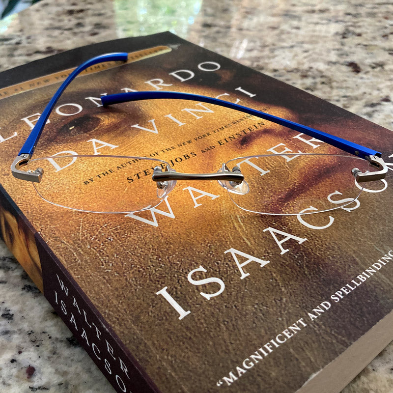 Visualites X Metal Reading Glasses with Round Lenses Sitting On A Book