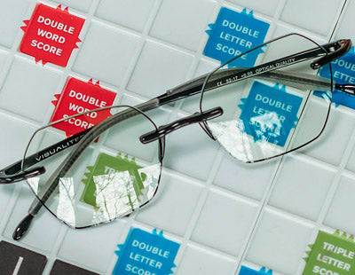 Black stylish reading glasses sitting on a scrabble board