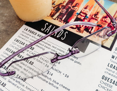 Violet color designer reading glasses sitting on a menu