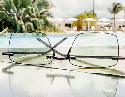Quality reading glasses sitting on a table by the pool