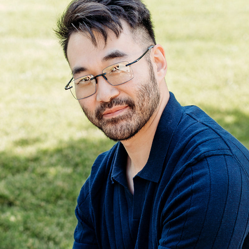 Man wearing designer Navy blue Esprit rimless readers with optical‑quality anti‑glare PC lenses