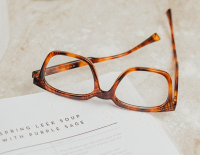 Designer Tortoise reading glasses sitting on a recipe book